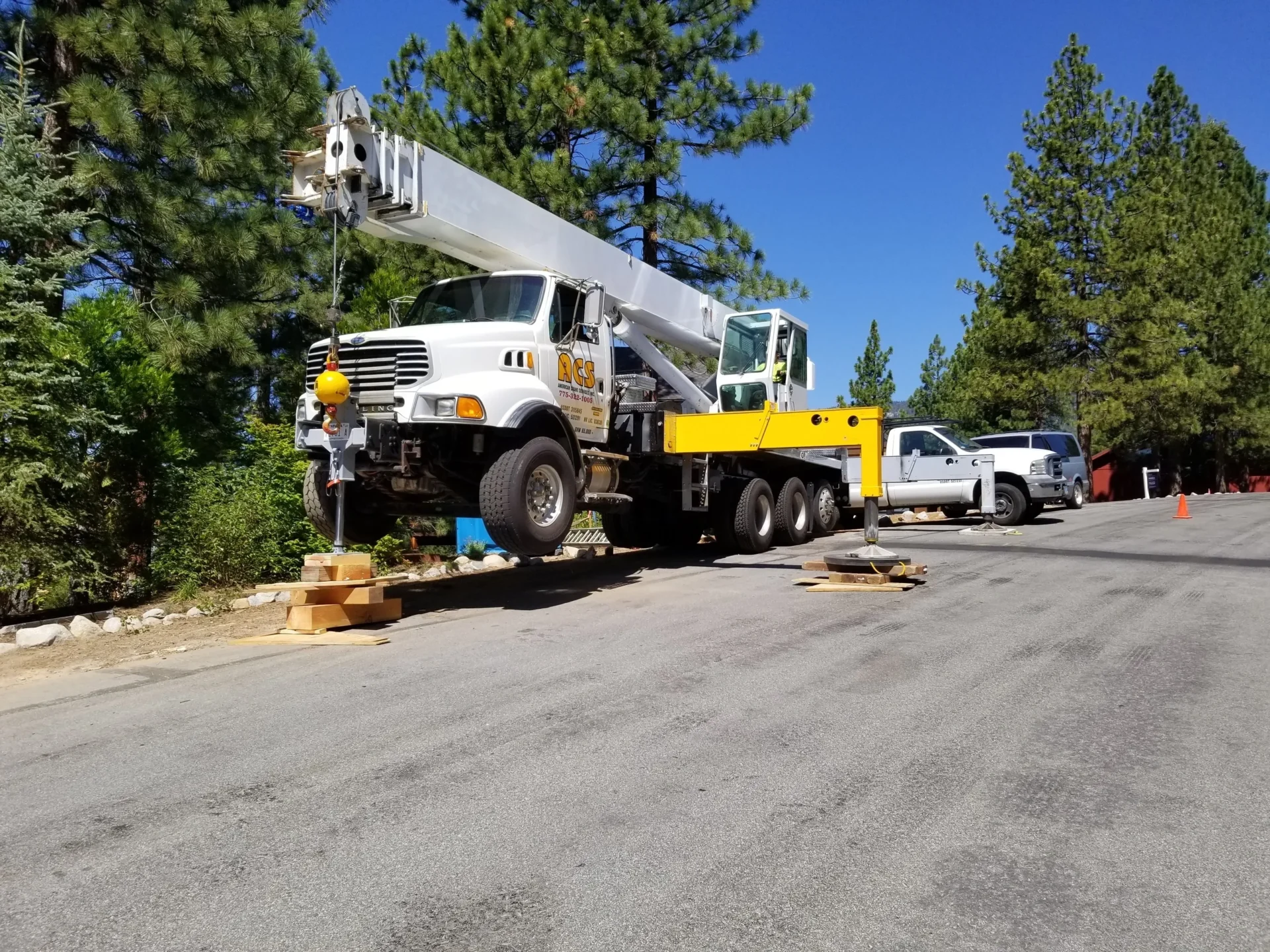 A crane is parked on the side of the road.