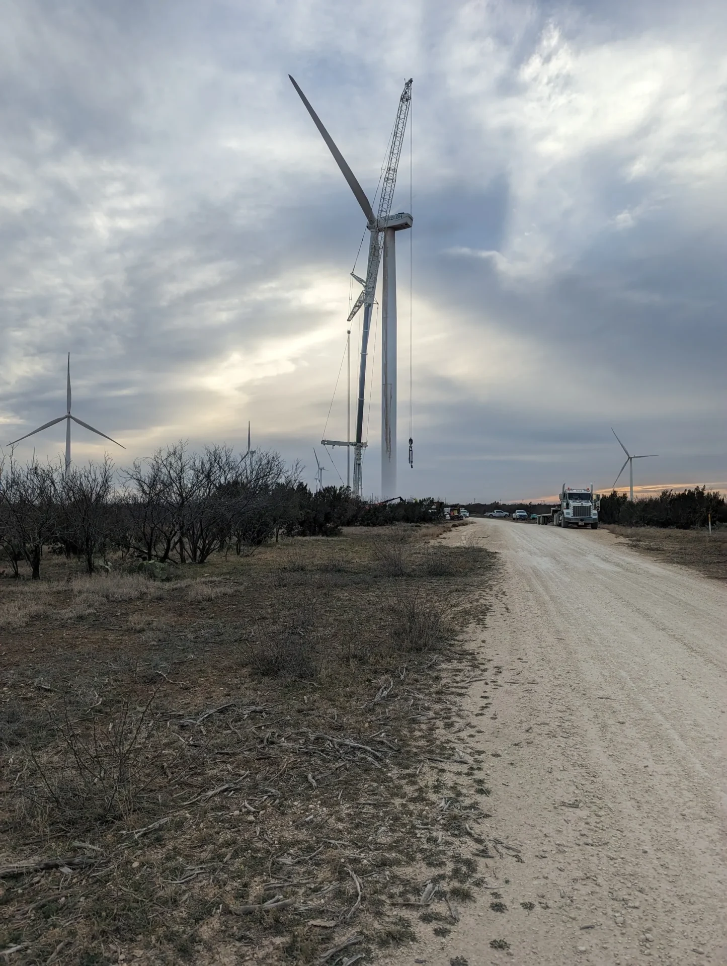 A road with wind turbines in the background.