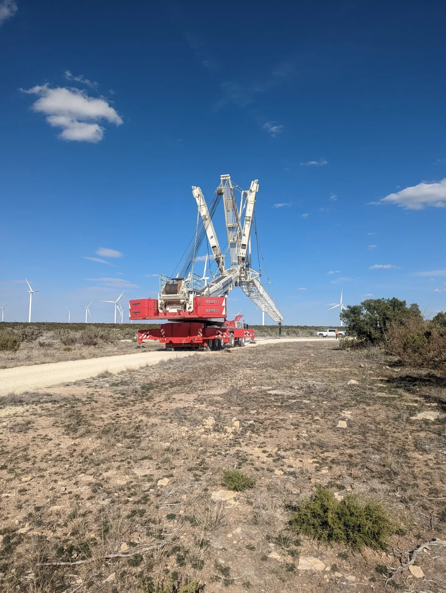 A red crane sitting on top of a dirt field.