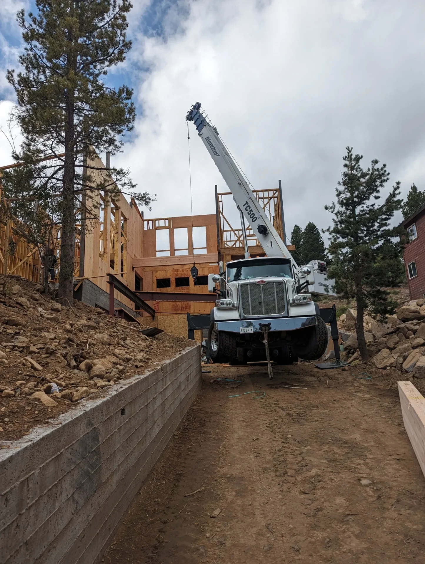 A crane is in the dirt near some houses.