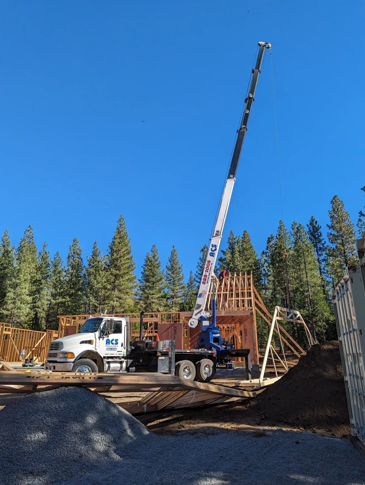 A crane is lifting up the top of a building.