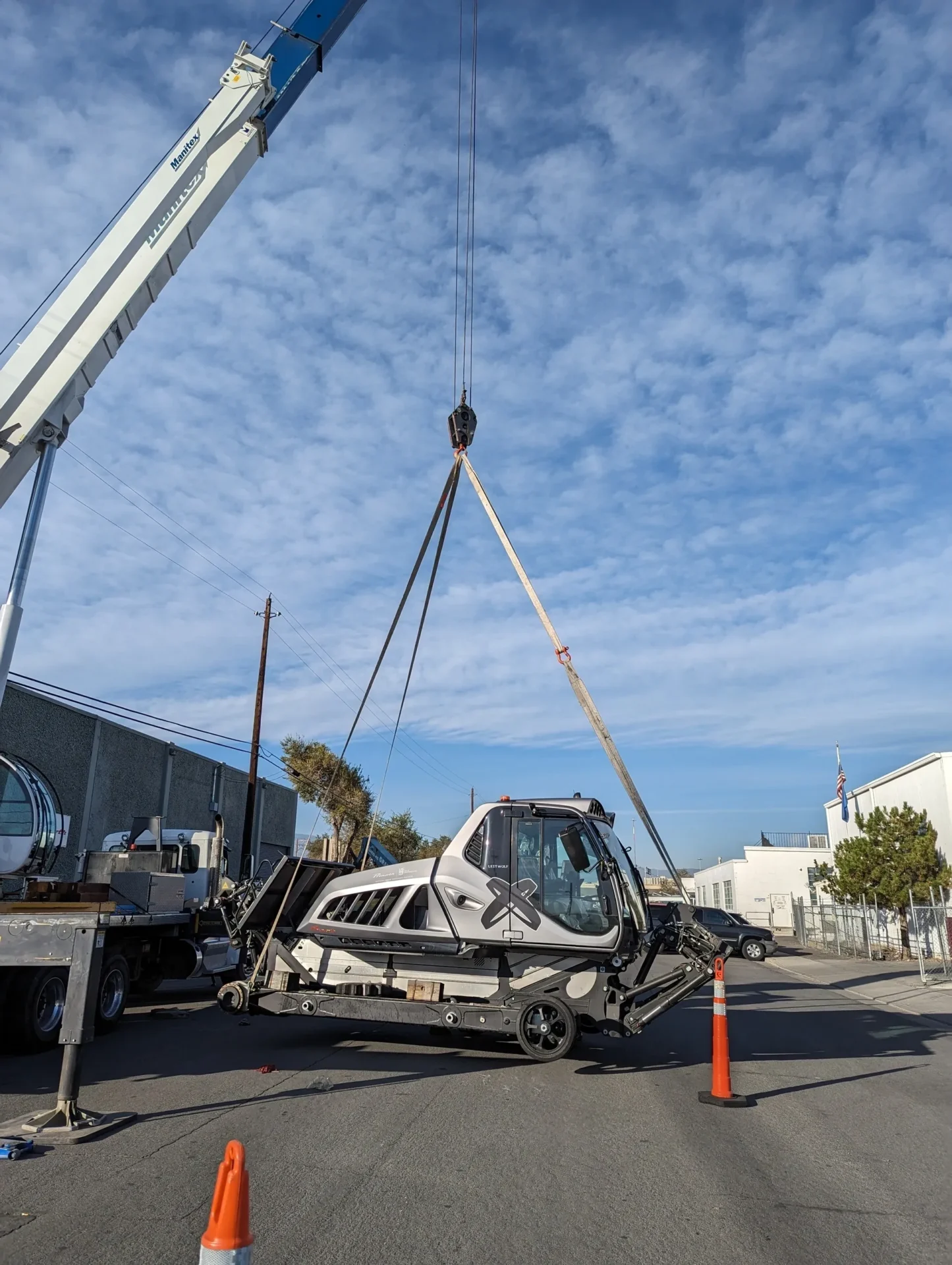 A crane is lifting a car into the air.