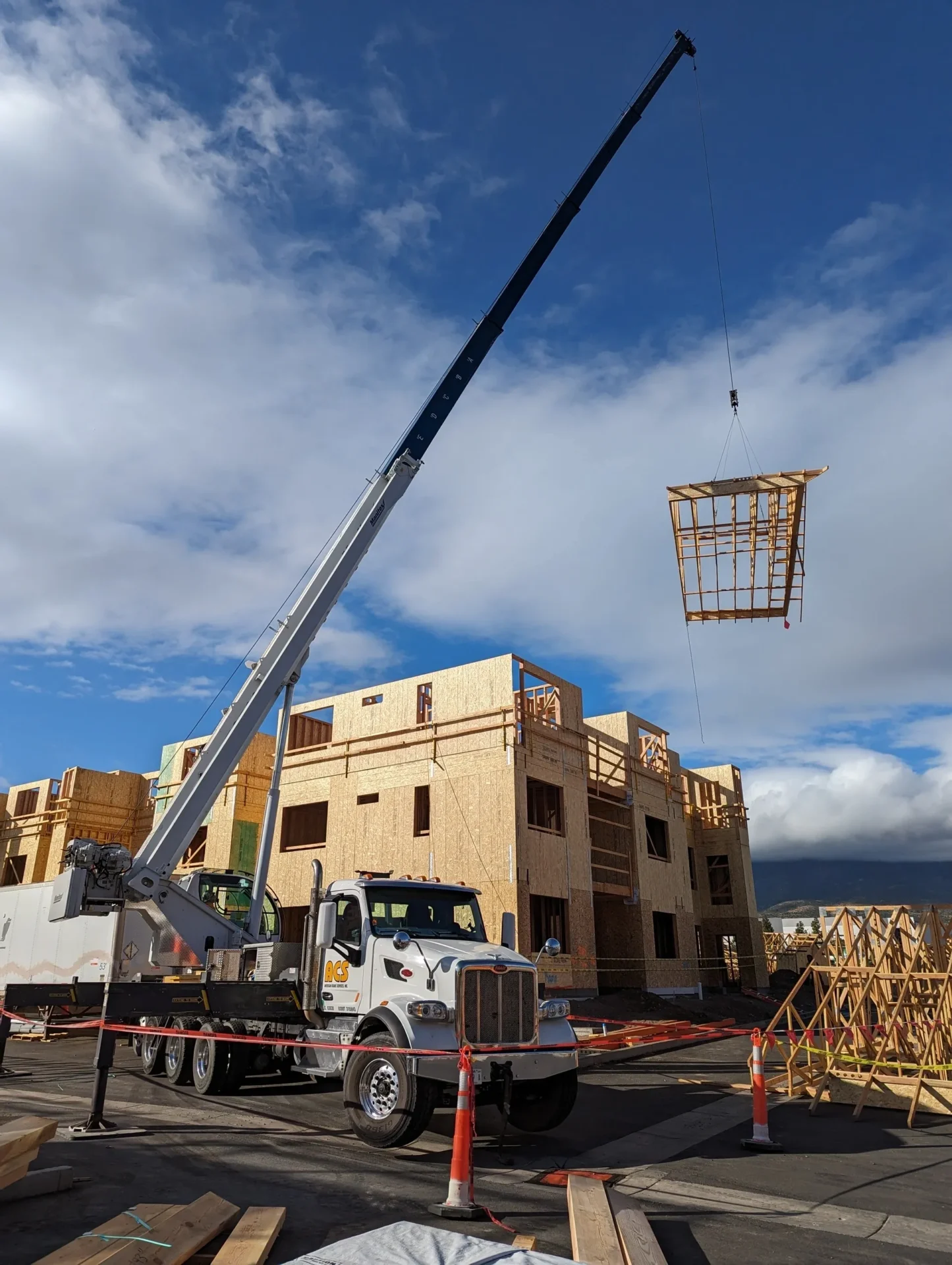 A crane is lifting a wooden structure into the air.