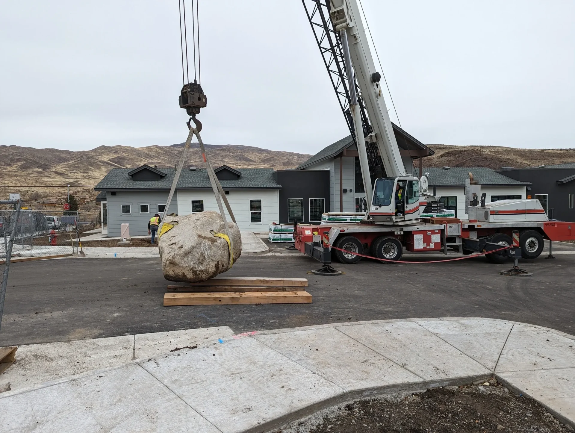 A crane is lifting a large rock.