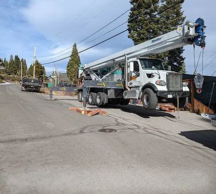 A crane truck is parked on the side of the road.